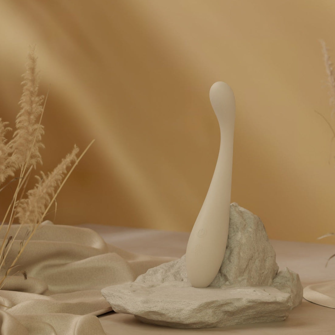 Velvet Rituals Celeste massager displayed as a hero shot on a stone pedestal with soft neutral tones, highlighting its elegant curved design