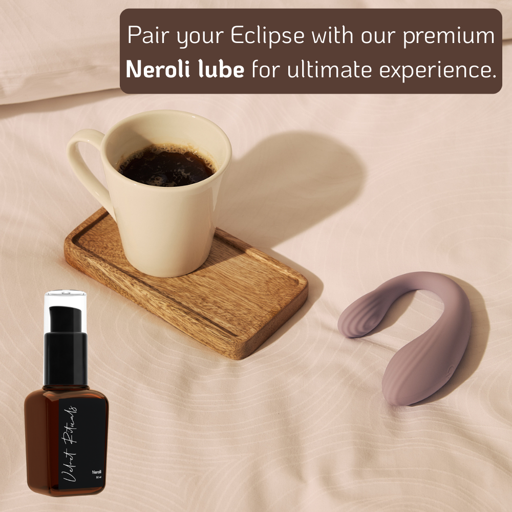 Velvet Rituals Eclipse couples vibrator placed beside a coffee cup and wooden tray, paired with Velvet Rituals Neroli premium intimate lubricant, styled in a soft, minimal lifestyle setting