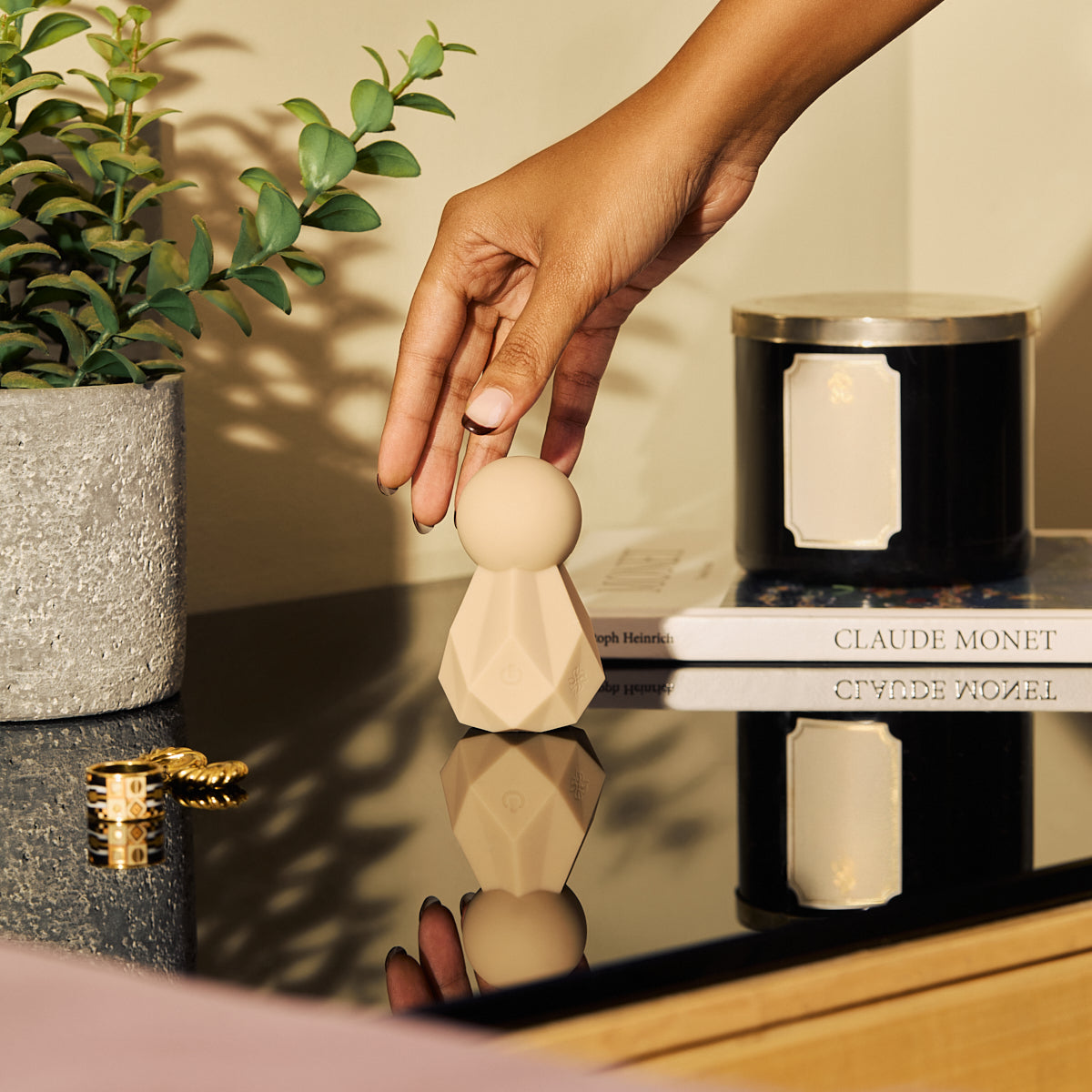 Velvet Rituals Estelle compact silicone massager styled in a modern home setting, shown as a discreet lifestyle product on a tabletop