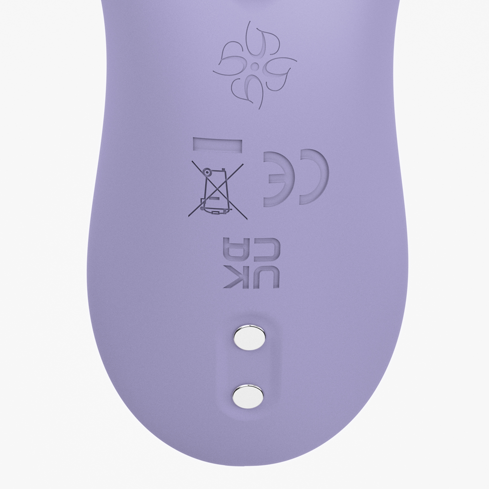 Close-up of Velvet Rituals Whisper showing magnetic charging pins and safety certifications on a smooth silicone finish